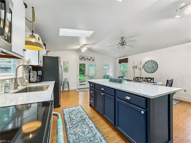 682 Bay Port Rd, Jamaica, VA 23079 - kitchen with dishwasher, blue cabinetry, vaulted ceiling, a skylight, and ceiling fan