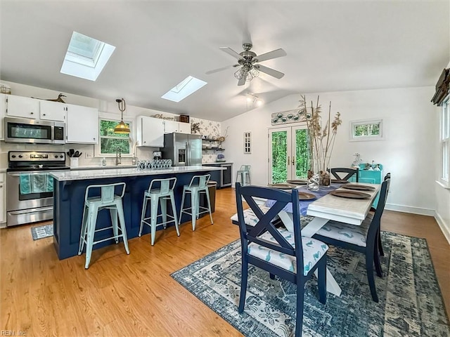 682 Bay Port Rd, Jamaica, VA 23079 - dining area with a skylight, healthy amount of natural light, vaulted ceiling, a ceiling fan, and light wood-type flooring