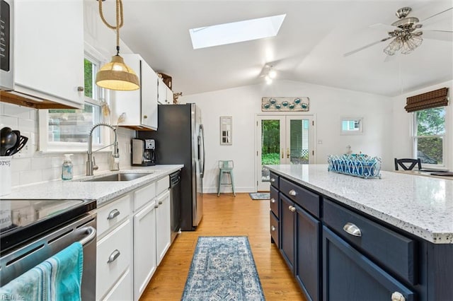 682 Bay Port Rd, Jamaica, VA 23079 - kitchen featuring white cabinets, a skylight, backsplash, black dishwasher, and vaulted ceiling
