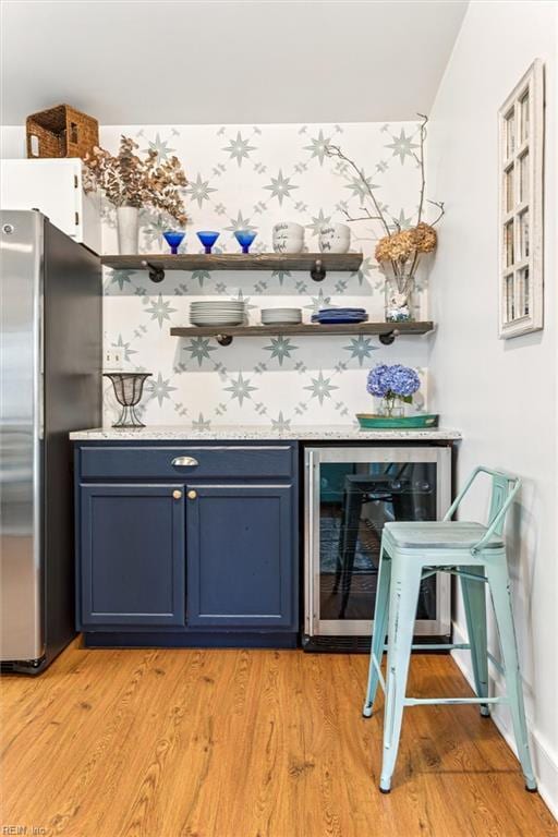 682 Bay Port Rd, Jamaica, VA 23079 - indoor dry bar with freestanding refrigerator, beverage cooler, light wood-style floors, and wallpapered walls