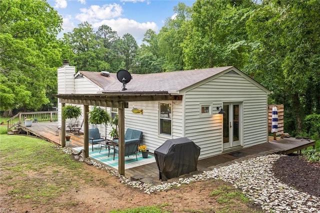 682 Bay Port Rd, Jamaica, VA 23079 - back of house with a deck, a chimney, view of scattered trees, and a shingled roof