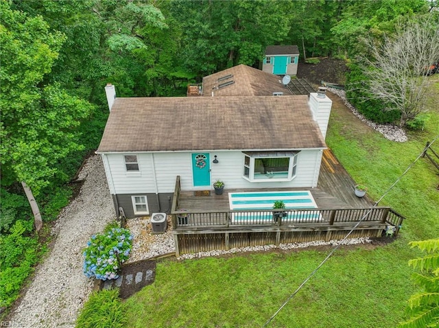 682 Bay Port Rd, Jamaica, VA 23079 - rear view of house featuring a chimney, a wooden deck, a lawn, and an outdoor pool
