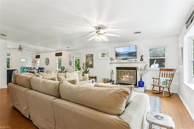 682 Bay Port Rd, Jamaica, VA 23079 - living room with ceiling fan, wood finished floors, and a lit fireplace