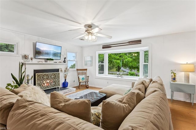 682 Bay Port Rd, Jamaica, VA 23079 - living room with ceiling fan, a lit fireplace, and wood finished floors