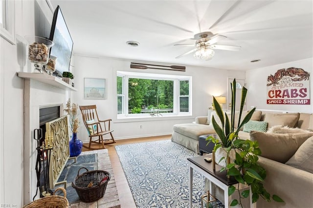 682 Bay Port Rd, Jamaica, VA 23079 - living room with ceiling fan, wood finished floors, and a fireplace with raised hearth