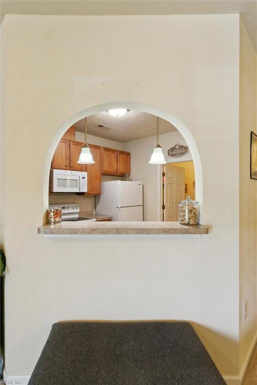 903 Rustads Cir, Williamsburg, VA 23188 - kitchen with white appliances, brown cabinetry, hanging light fixtures, and arched walkways