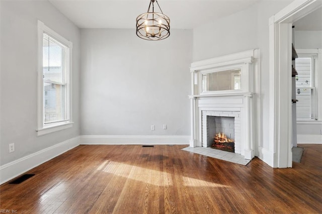 1145 24th St, Newport News, VA 23607 - unfurnished living room featuring wood finished floors, a fireplace, and a chandelier
