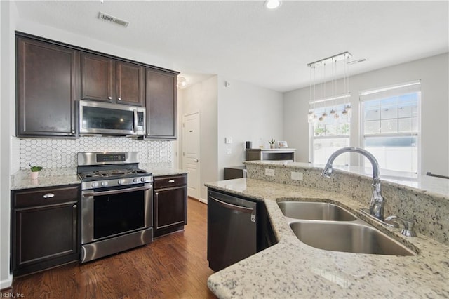 2137 Bellflower Way, Chesapeake, VA 23323 - kitchen with stainless steel appliances, dark wood-type flooring, backsplash, dark brown cabinetry, and light stone countertops