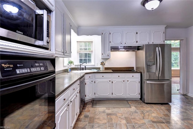 112 Archer Rd, Newport News, VA 23606 - kitchen featuring black appliances, under cabinet range hood, stone finish floors, healthy amount of natural light, and ornamental molding