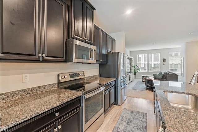 1728 Shorebird Ln, Virginia Beach, VA 23456 - kitchen with appliances with stainless steel finishes, light wood-style flooring, open floor plan, dark stone counters, and recessed lighting