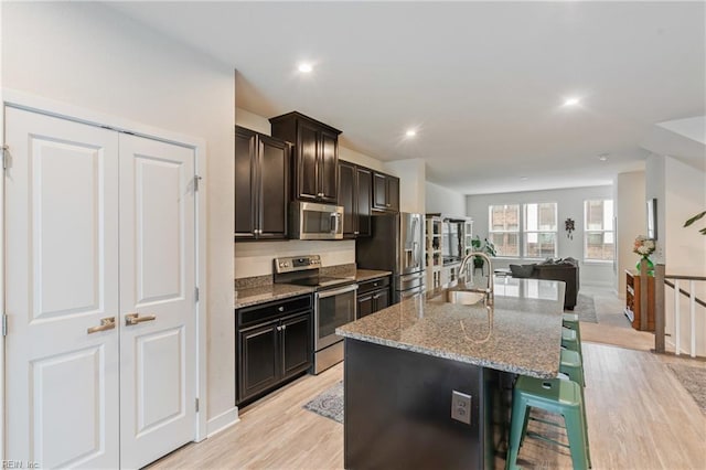 1728 Shorebird Ln, Virginia Beach, VA 23456 - kitchen featuring stainless steel appliances, a breakfast bar area, light wood-type flooring, light stone counters, and recessed lighting