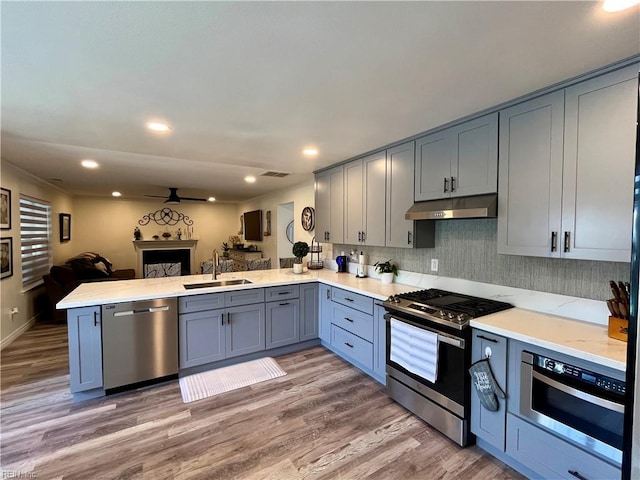 120 Lancelot Dr, Suffolk, VA 23434 - kitchen featuring stainless steel appliances, under cabinet range hood, gray cabinetry, open floor plan, and a peninsula