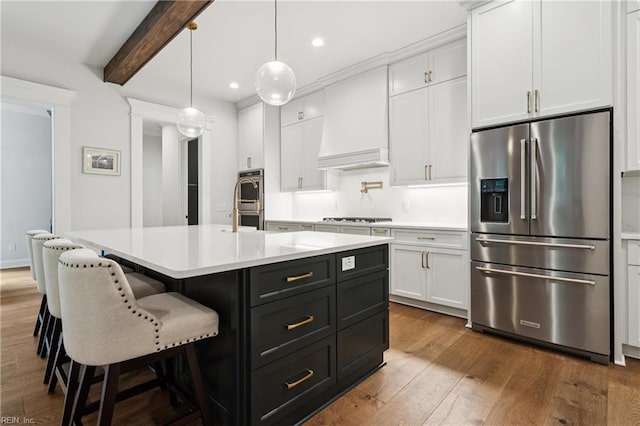 104 Tucker Ct, Carrollton, VA 23314 - kitchen featuring appliances with stainless steel finishes, white cabinetry, custom exhaust hood, light countertops, and dark wood-style flooring