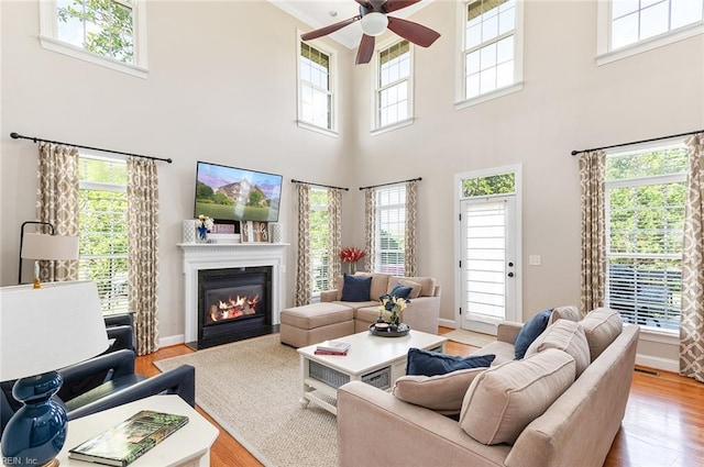 101 Ryder, Smithfield, VA 23430 - living area with a ceiling fan, healthy amount of natural light, a towering ceiling, a fireplace with flush hearth, and light wood-style floors