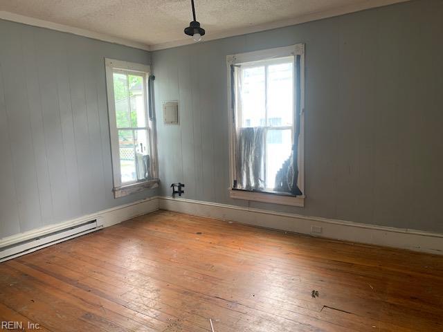 603 N High St, Franklin, VA 23851 - unfurnished room featuring wood-type flooring, a textured ceiling, and a baseboard radiator