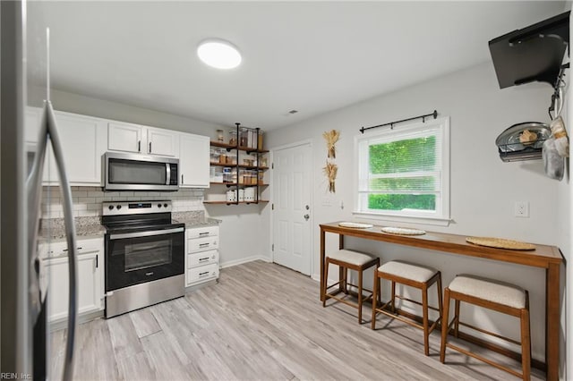 2601 Shell Rd, Hampton, VA 23661 - kitchen with appliances with stainless steel finishes, decorative backsplash, white cabinets, open shelves, and light wood-style flooring