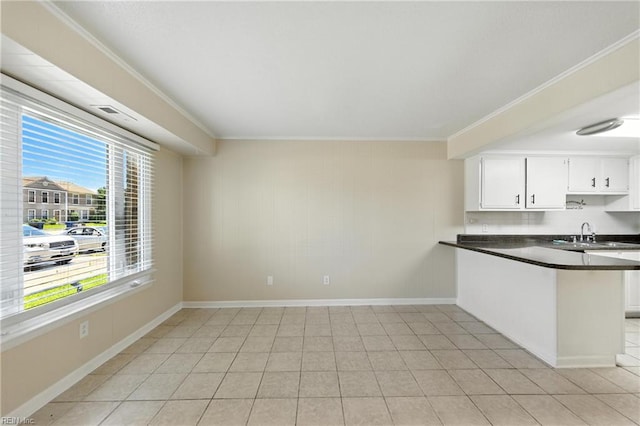569 Chancery Ln, Virginia Beach, VA 23452 - kitchen with dark countertops, ornamental molding, a peninsula, and white cabinetry