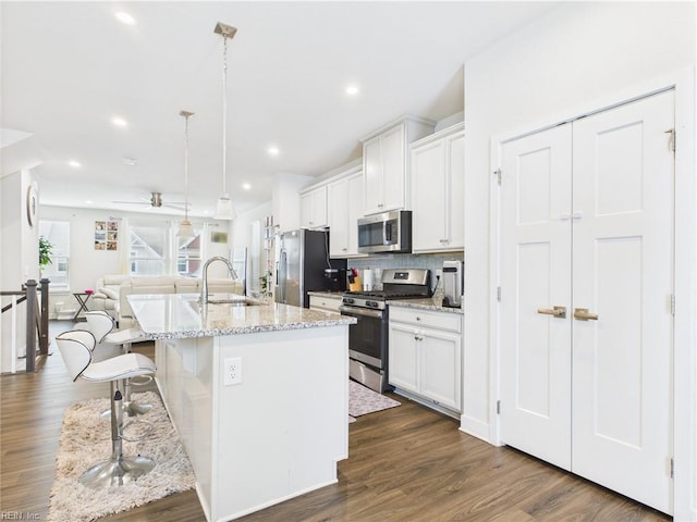 1732 Defiance Dr, Chesapeake, VA 23323 - kitchen featuring stainless steel appliances, open floor plan, a kitchen bar, an island with sink, and white cabinetry