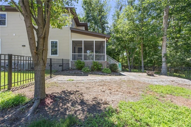 102 Batten Cv, Carrollton, VA 23314 - back of house with a sunroom, an outdoor fire pit, and a fenced backyard