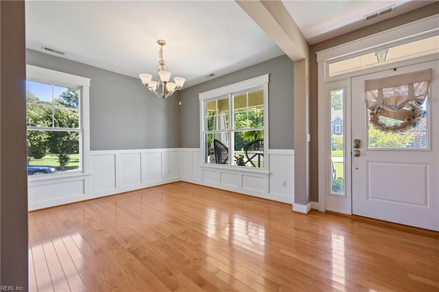 102 Batten Cv, Carrollton, VA 23314 - foyer with a chandelier, healthy amount of natural light, a wainscoted wall, wood finished floors, and a decorative wall