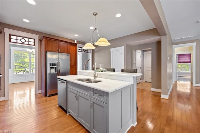 102 Batten Cv, Carrollton, VA 23314 - kitchen with appliances with stainless steel finishes, light countertops, gray cabinets, light wood-style floors, and an island with sink