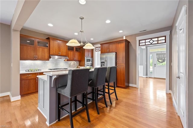 102 Batten Cv, Carrollton, VA 23314 - kitchen featuring under cabinet range hood, appliances with stainless steel finishes, light countertops, brown cabinetry, and recessed lighting