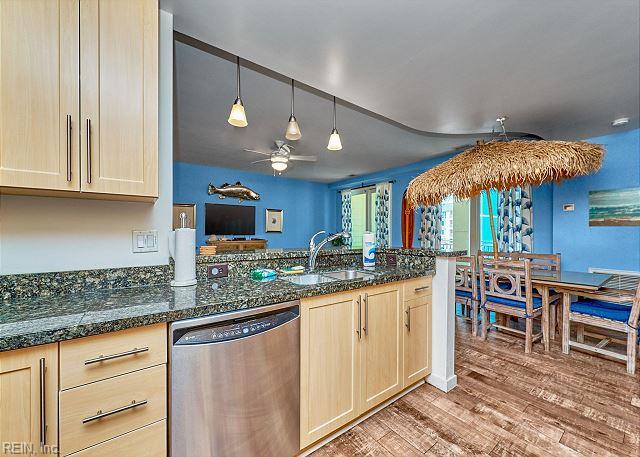 3738 Sandpiper Rd Unit 214B, Virginia Beach, VA 23456 - kitchen featuring dishwasher, light wood-style flooring, a ceiling fan, hanging light fixtures, and dark stone countertops