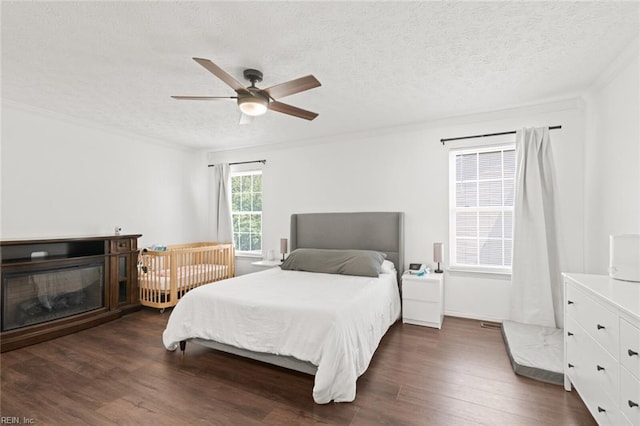730 Kings Ridge Dr, Newport News, VA 23608 - bedroom with dark wood-style flooring, a textured ceiling, ornamental molding, a glass covered fireplace, and ceiling fan