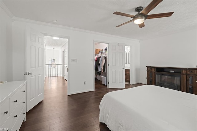 730 Kings Ridge Dr, Newport News, VA 23608 - bedroom with dark wood-type flooring, a walk in closet, ornamental molding, a closet, and ceiling fan