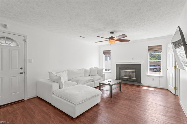 730 Kings Ridge Dr, Newport News, VA 23608 - living room with dark wood-style flooring, a textured ceiling, a ceiling fan, a glass covered fireplace, and crown molding