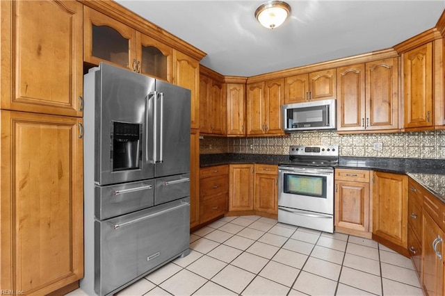 160 Outlaw Ln, Suffolk, VA 23435 - kitchen with stainless steel appliances, light tile patterned flooring, backsplash, dark countertops, and brown cabinetry