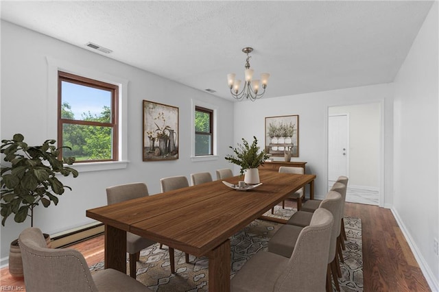 160 Outlaw Ln, Suffolk, VA 23435 - dining room with a baseboard heating unit, a chandelier, and wood finished floors