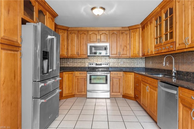 160 Outlaw Ln, Suffolk, VA 23435 - kitchen with appliances with stainless steel finishes, light tile patterned flooring, brown cabinets, and glass insert cabinets