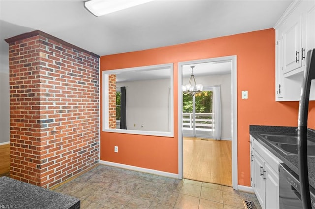 518 Spring Trce, Williamsburg, VA 23188 - kitchen with dishwasher, white cabinets, a chandelier, dark countertops, and brick wall