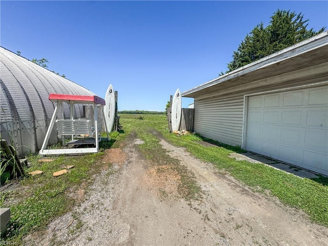 1912 Pleasant Ridge Rd, Virginia Beach, VA 23457 - view of yard with dirt driveway, a garage, and an outdoor structure