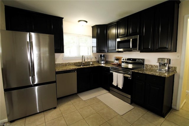 1353 King Arthur Dr, Chesapeake, VA 23323 - kitchen featuring stainless steel appliances, dark cabinetry, dark stone countertops, and light tile patterned floors