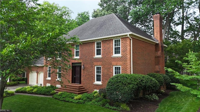 1217 Worthington Ln, Virginia Beach, VA 23464 - view of front facade with a chimney, brick siding, a garage, roof with shingles, and a front yard