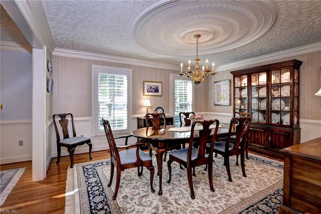 1217 Worthington Ln, Virginia Beach, VA 23464 - dining room featuring healthy amount of natural light, a textured ceiling, wood finished floors, a chandelier, and ornamental molding