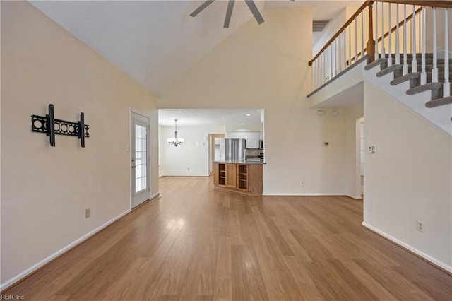 1301 Silverthorne Ct, Chesapeake, VA 23321 - unfurnished living room with ceiling fan, high vaulted ceiling, a chandelier, light wood-type flooring, and stairs