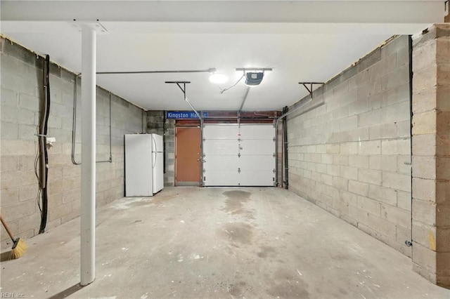 233 Mill Point Dr, Hampton, VA 23669 - garage featuring freestanding refrigerator, concrete block wall, and a garage door opener