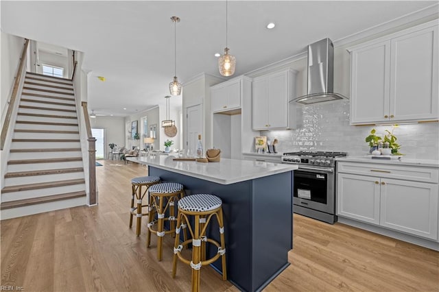 516 26th St, Virginia Beach, VA 23451 - kitchen with wall chimney exhaust hood, high end range, light wood-style floors, a breakfast bar area, and recessed lighting