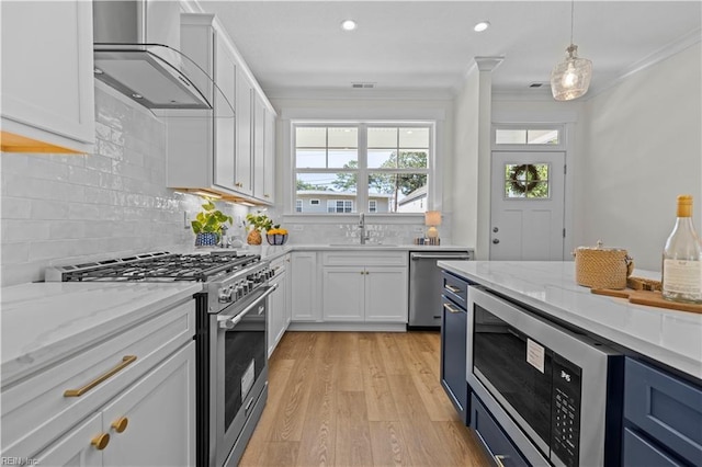 516 26th St, Virginia Beach, VA 23451 - kitchen featuring appliances with stainless steel finishes, wall chimney exhaust hood, crown molding, light wood-type flooring, and plenty of natural light