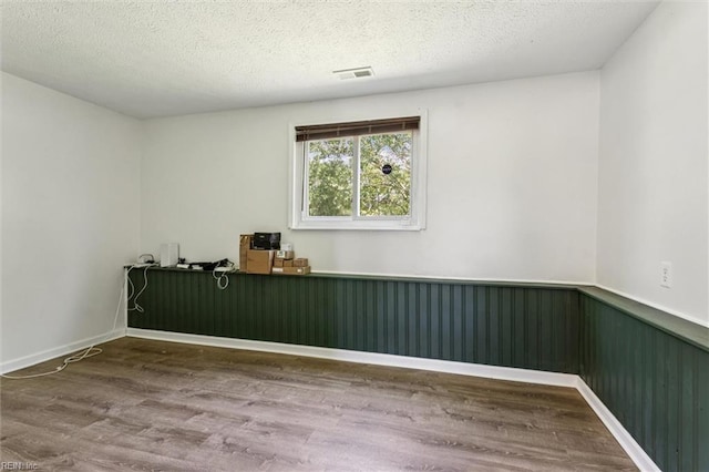 1521 Peabody Dr, Hampton, VA 23666 - spare room featuring a wainscoted wall, wood finished floors, and a textured ceiling