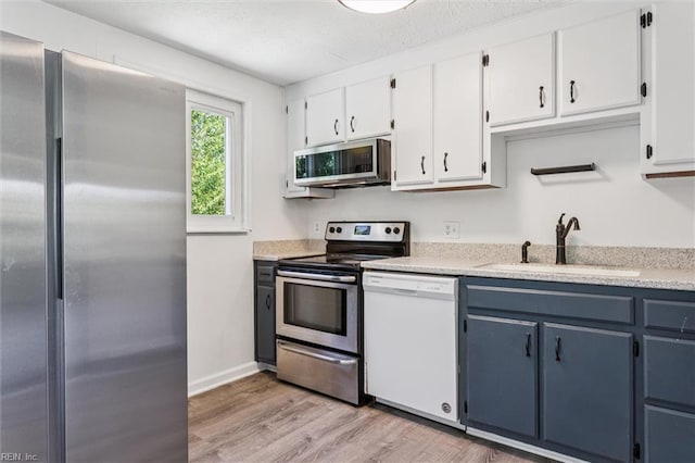 1521 Peabody Dr, Hampton, VA 23666 - kitchen featuring appliances with stainless steel finishes, light wood-type flooring, white cabinets, and blue cabinets