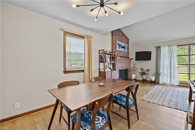 2218 Haywood Ave, Chesapeake, VA 23324 - dining room featuring a chandelier, lofted ceiling, a fireplace, and light wood finished floors