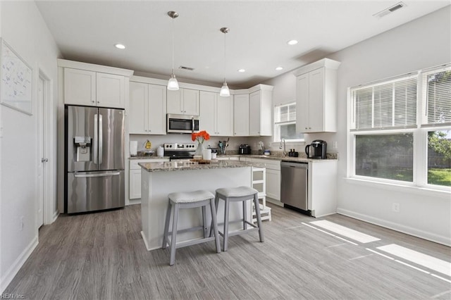 208 Parkdale Ave, Hampton, VA 23669 - kitchen with appliances with stainless steel finishes, a center island, light wood-style floors, white cabinets, and a kitchen breakfast bar