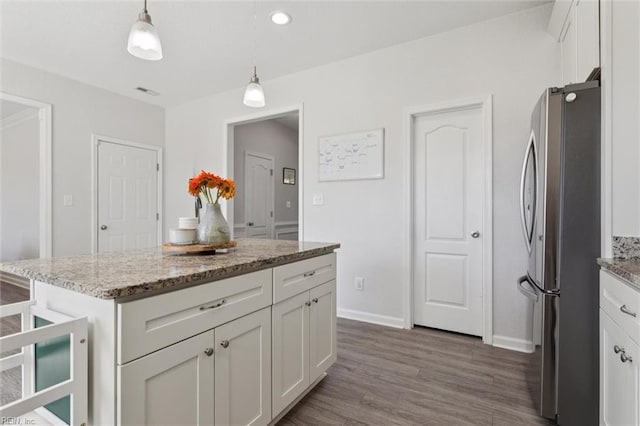 208 Parkdale Ave, Hampton, VA 23669 - kitchen featuring freestanding refrigerator, white cabinets, dark wood-style floors, hanging light fixtures, and light stone countertops