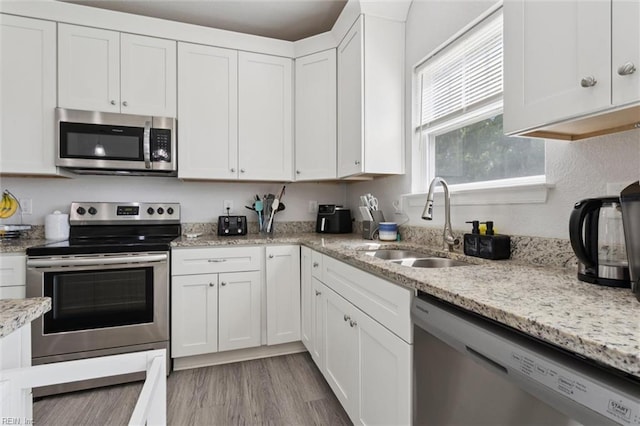 208 Parkdale Ave, Hampton, VA 23669 - kitchen featuring stainless steel appliances, white cabinets, light wood-type flooring, and light stone counters