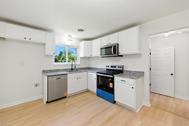 3144 Aaron Dr, Chesapeake, VA 23323 - kitchen with appliances with stainless steel finishes, light wood finished floors, white cabinets, and light stone countertops