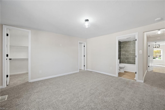 10 Church St, Windsor, VA 23487 - unfurnished bedroom featuring carpet flooring, a walk in closet, ensuite bathroom, and a closet
